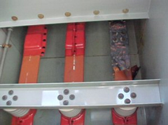 An inside view of the duct showing a copper bus bar in advanced stages of failure.